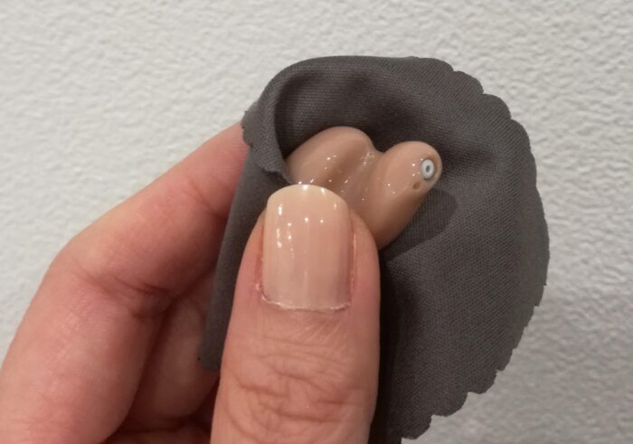 耳あな型補聴器を拭く様子