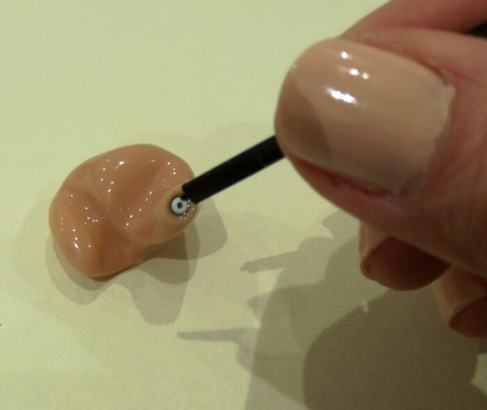 耳あな型補聴器の耳垢フィルターを交換している様子です