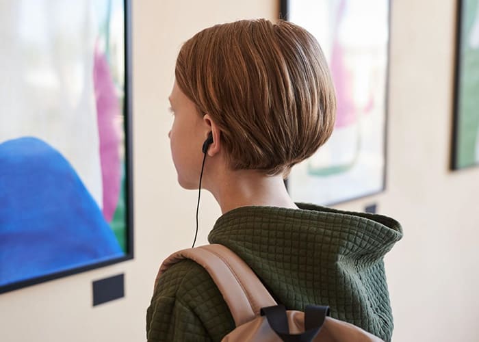 イヤホンをしながら絵画を見る女性